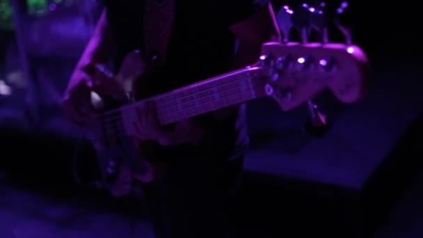 Un primer plano de un macho tocando la guitarra en un concierto — Vídeo de stock