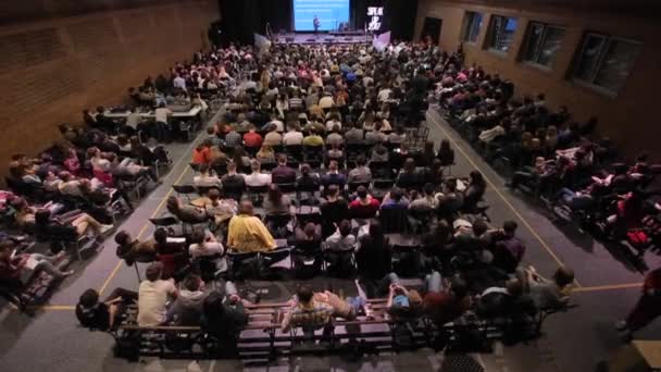 Brest, Bielorrússia - 9 de maio de 2018: vista superior de centenas de estudantes em uma grande sala de aula. Sentam-se e ouvem o professor — Vídeo de Stock