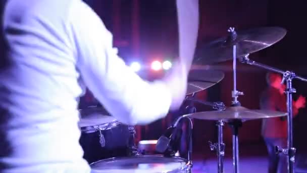 Sebuah close-up dari seorang pria bermain instrumen perkusi sementara orang lain bernyanyi di atas panggung. Pencahayaan konser — Stok Video