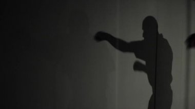 Eğitim bir erkek boxer gölgesi. Pratik yumruklar. Mücadele önce. Hareketli bir gölge