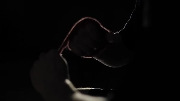 Een bokser bindt een rood bandage op zijn rechterhand. Voorbereiding op de strijd. Een close-up weergave — Stockvideo