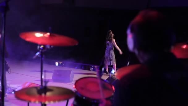 Babrujsk, Wit-Rusland - juli 31, 2018: Rockconcert. Een prachtige vrouwelijke zanger en een drummer presteren op het podium. Achteraanzicht — Stockvideo