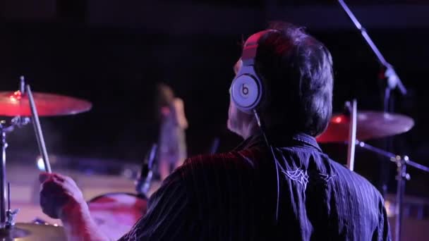 Bobruisk,Belarus - JULY 31, 2018: Rock concert. Back view of a mature male drummer playing while a beautiful woman is singing. The end of the song — Stock Video