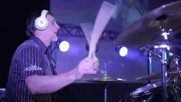 Bobruisk, Bělorusko - 31. července 2018: Rockový koncert. Boční pohled na mužský bubeník hraje na bicí na jevišti na koncertě. Blikající bodová světla na pozadí — Stock video