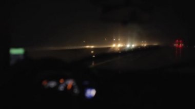 Bir araba karayolunda gece yağmurda sürüş. Çalışan silecekler. Bir araba iç. Hız göstergesi