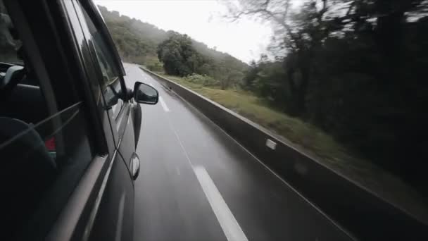 Een zwarte auto gaat op de bochtige, bergachtige weg. Reizen in de bergen — Stockvideo