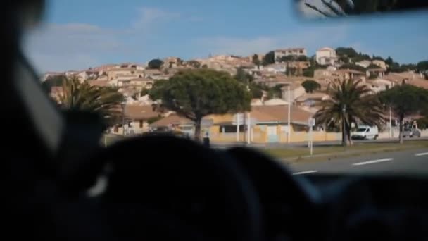 Kör längs gatan med vackra träd, palmer och massor av hus på vänster sida. Visa från inne i bilen — Stockvideo