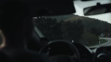 Arkadan Görünüş dağlarda dolambaçlı yol üzerinde bir araba sürücüsü