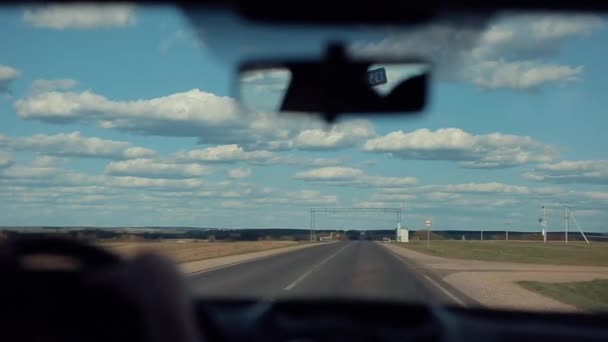 On suit la route de campagne. Champ large et ciel bleu clair avec de gros nuages — Video