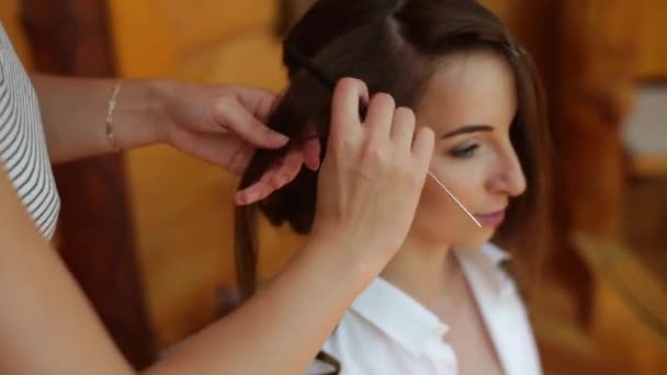 A close up view of a professional doing a wedding hairstyle for a beautiful young bride. The brides morning. A pretty brunette — Stock Video