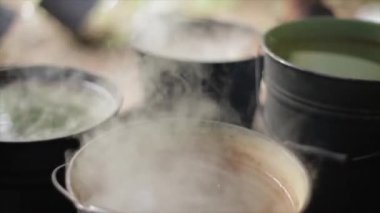 Eski moda bir kova içine sıcak su dökme bir adam. Doğa.