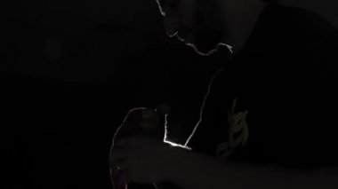 Bir close-up güçlü bir boksör için mücadele hazırlanıyor. Adam ellerini kırmızı bandaj ile kaydırma