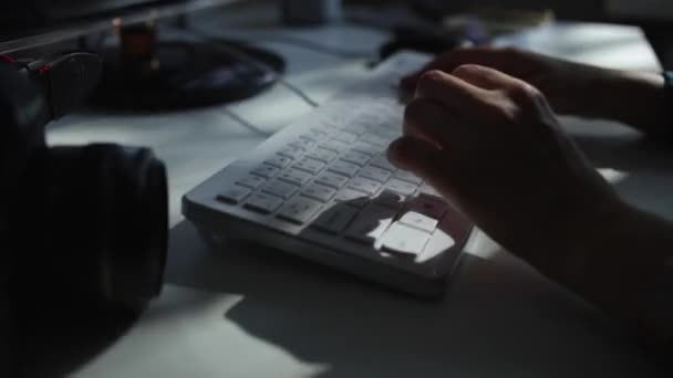 Un primer plano de las manos femeninas escribiendo en un teclado blanco. El juego de la luz del sol — Vídeo de stock