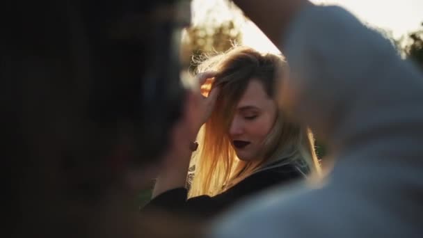 Een close-up van een fotograaf schieten een mooi blond meisje buiten — Stockvideo