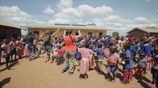 KENYA, KISUMU - MAIO 20, 2017: Crianças africanas dançando fora, repetindo movimentos após mulheres caucasianas . — Vídeo de Stock