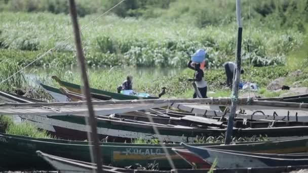 Kenya, Kisumu - 20 Mayıs 2017: göl, iskele ve tekneler sahilde görünüm onların çamaşır Afrika insanlar. — Stok video