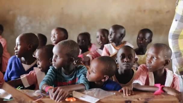 Keňa, Kisumu - 20 května 2017: Krásné malé děti sedí u stolu v místní škole na Afriku. — Stock video