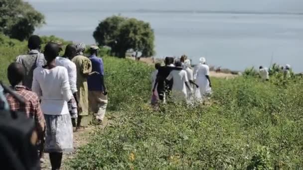 KENYA, KISUMU - MAIO 20, 2017: Grande grupo de povos africanos e caucasianos estão indo juntos para a costa do mar . — Vídeo de Stock