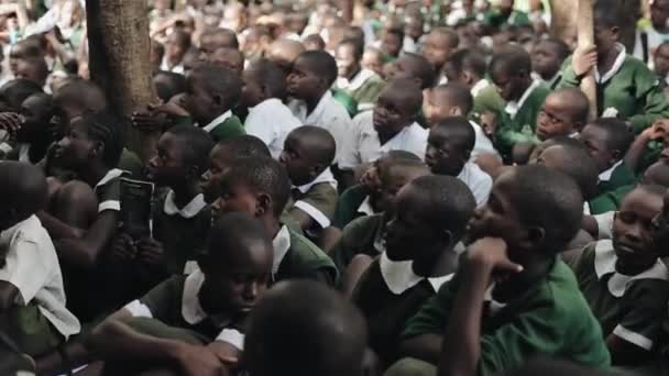 KENYA, KISUMU - MAIO 20, 2017: Grande grupo de crianças africanas de uniforme sentadas no quintal da escola juntas . — Vídeo de Stock