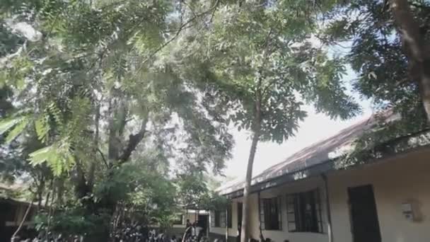 KENYA, KISUMU - 20 MAI 2017 : Un grand groupe d'enfants africains en uniforme assis sur un sol près de l'école . — Video