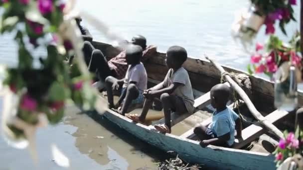 KENYA, KISUMU - MAIO 20, 2017: Grupo de crianças africanas sentadas no barco e olhando para a água do mar . — Vídeo de Stock