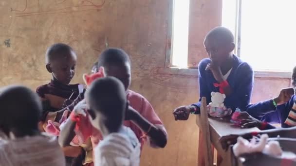 Kenya, Kisumu - 20 maj 2017: Glada afrikanska barn leker med leksaker, äta godis i skolan. — Stockvideo