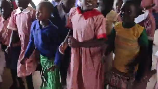 Kenya, Kisumu - 2017. május 20.: Boldog afrikai gyermekek ismétlődő táncolni mozgását, kaukázusi nő után. — Stock videók