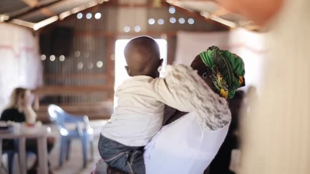 KENYA, KISUMU - 20 MAGGIO 2017: Casa della famiglia africana. Giovane donna tiene il suo piccolo figlio nelle sue mani . — Video Stock