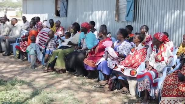 KENYA, KISUMU - MAY 20, 2017: People from local african tribe maasai sitting on the chairs and looking somewhere. — Stock Video