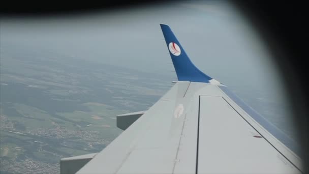 Kenia, Kisumu - 20 mei 2017: Uitzicht vanuit het raam van het vliegtuig op de vleugel boven de stad. Een passagiersvliegtuig vertrekt vanaf de luchthaven. — Stockvideo