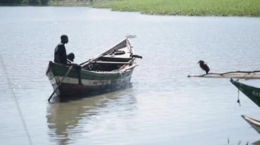 Kenya, Kisumu - 20 Mayıs 2017: Afrika adam sandalda oturan yalnız denizde yüzme güzel manzara.