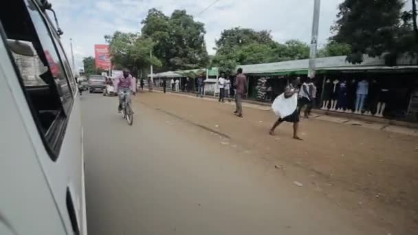 KENIA, KISUMU - 20 DE MAYO DE 2017: Vista a través del parabrisas desde el interior de un automóvil. Coche está montando a través de la ciudad en África cerca del mercado abierto . — Vídeo de stock