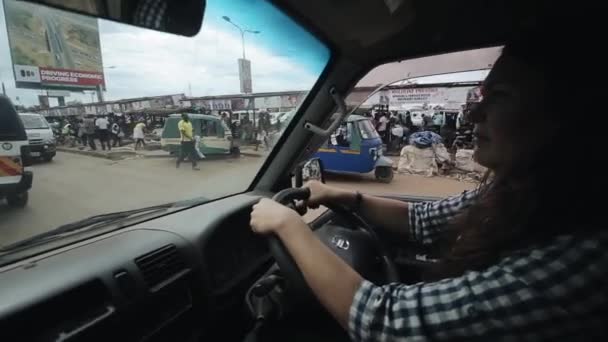 Keňa, Kisumu - 20 května 2017: Mladá krásná žena řídí vůz přes rušné město v Africe v dopravních zácpách. — Stock video