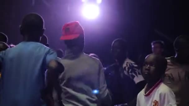Kenya, kisumu - 20. Mai 2017: afrikanische Jungen und Mädchen, Teenager tanzen gemeinsam in einem dunklen Raum mit hellem Licht. — Stockvideo