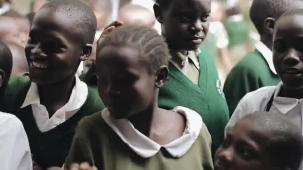 Kenya, kisumu - 20. Mai 2017: glückliche afrikanische Kinder in grüner Uniform geben fünf an kaukasische Männer. — Stockvideo