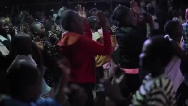 KENYA, KISUMU MAIO 20, 2017: Grande grupo de crianças, meninos e meninas africanos dançando, pulando, batendo palmas em grande sala juntos . — Vídeo de Stock