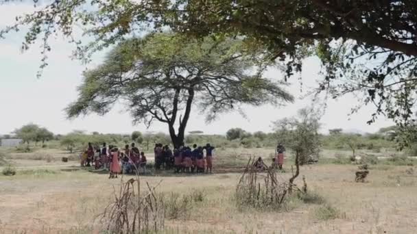 Африканские дети в форме стоят под деревом и разговаривают . — стоковое видео