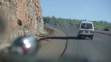--Dan hareket eden bir arabanın içinde görüntüleyin. Otomobil sürme aracılığıyla ülke road, Afrika parlak güneşli bir günde serpantin üzerinde döner.