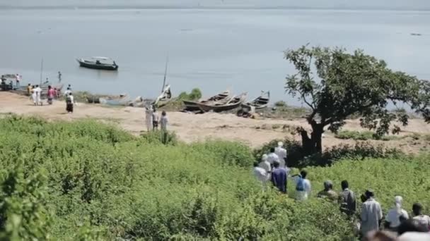 Grote groep Afrikaanse en Kaukasische mensen gaan samen aan de oever van de zee, strand. — Stockvideo