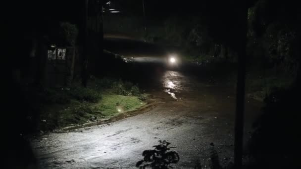 Motorrijder rijdt op een natte weg 's avonds laat in de regen. Bekijk op regen en lamp. — Stockvideo