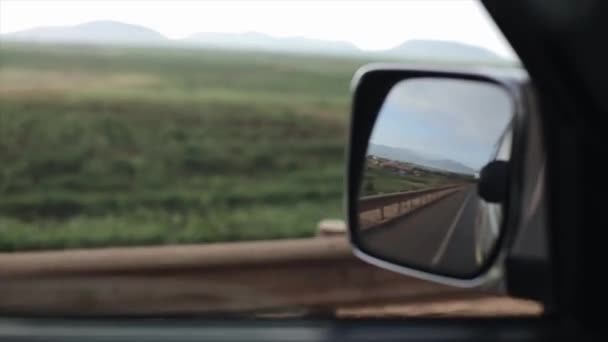 Vista desde el interior c coche en movimiento. El automóvil está atravesando los campos escénicos, el campo en África . — Vídeos de Stock