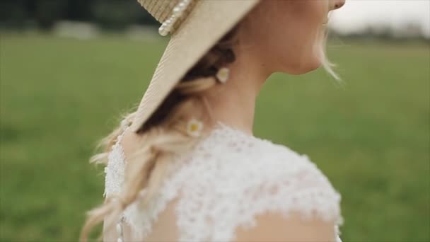 Side close view of a beautiful bride standing outdoors against blurred green background — Stock Video