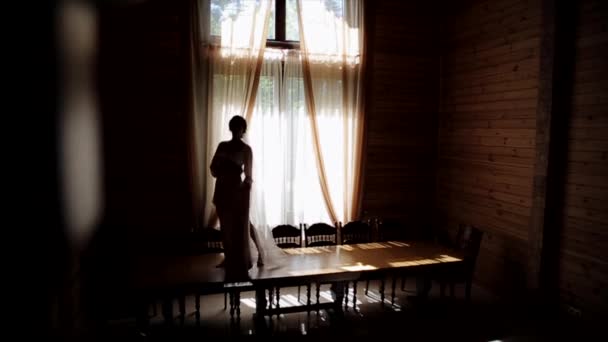 Morning before the wedding. A bride in pajamas and veil is walking on the table holding her wedding dress — Stock Video