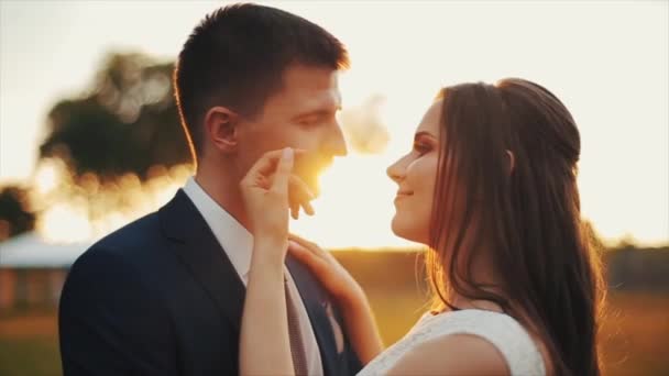 Glücklich lächelndes junges verliebtes Paar im Freien. Küssen. farbenfroher Sonnenuntergang. Hochzeitstag. — Stockvideo