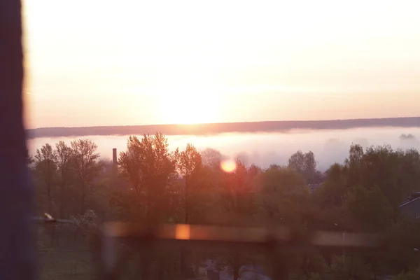 View from the window. Fog on the background of the dawn