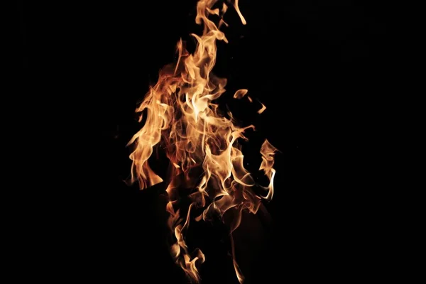 Grumes brûlantes dans les flammes flamboyantes du feu de joie . — Photo