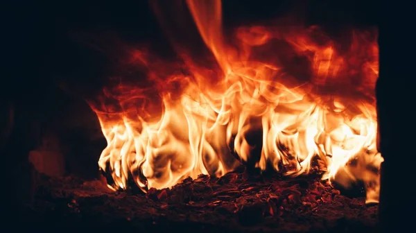 Grumes brûlantes dans les flammes flamboyantes de la cheminée . — Photo