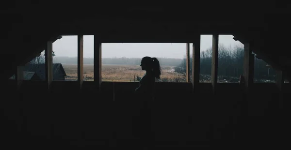 Silhouet van mooie meisje in het dorp. Model op de achtergrond van een bos. Vrouw meisje voor het raam. — Stockfoto