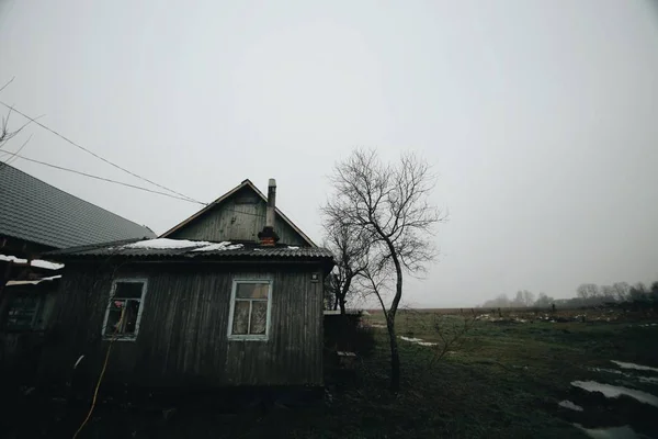 Drewniany, stary dom na wiosnę. Brudne natura wokół. — Zdjęcie stockowe