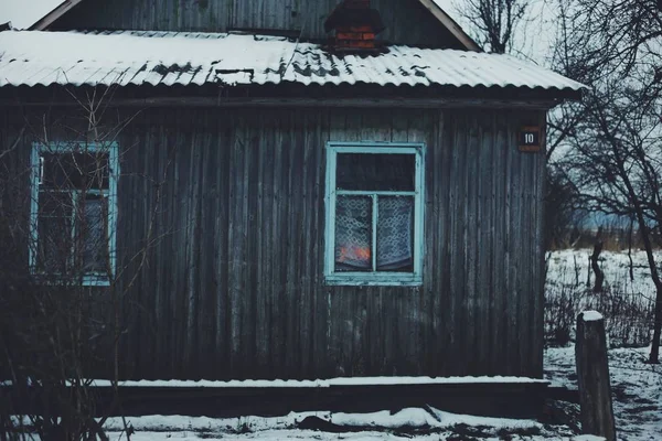 Παλιό σπίτι ξύλινο χιόνι το χειμώνα. Αρκετό χιόνι στη στέγη — Φωτογραφία Αρχείου
